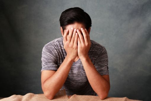 顔を覆う男性